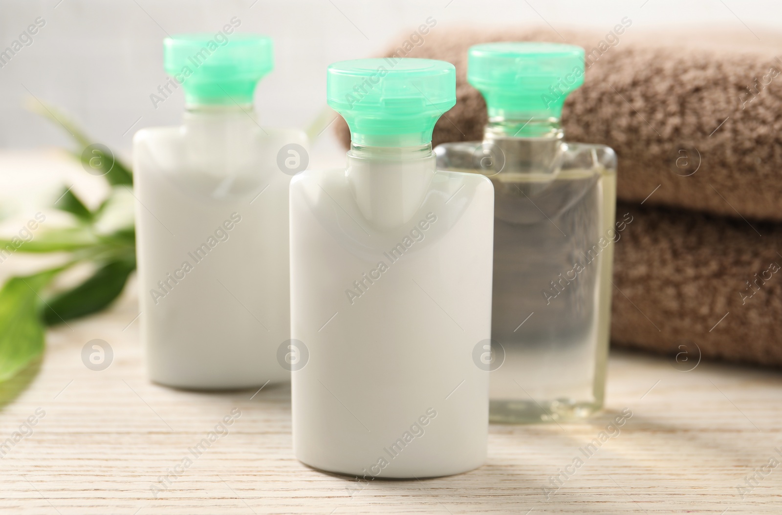 Photo of Mini bottles of cosmetic products on white wooden table