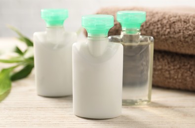 Photo of Mini bottles of cosmetic products on white wooden table