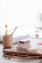 Photo of Soap bars and towel on table against blurred background. Space for text
