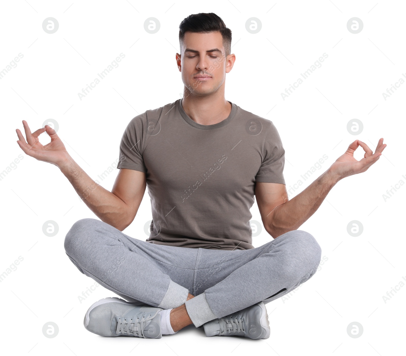 Photo of Handsome man meditating on white background. Harmony and zen