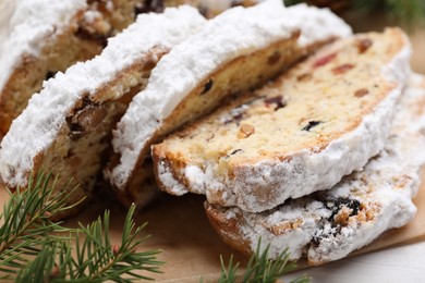 Traditional Christmas Stollen with icing sugar on white table, closeup