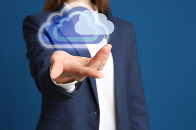 Image of Woman holding virtual clouds icon on blue background, closeup of hand. Data storage concept