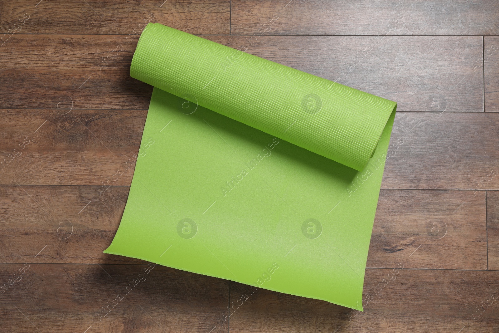 Photo of Bright camping mat on wooden background, top view
