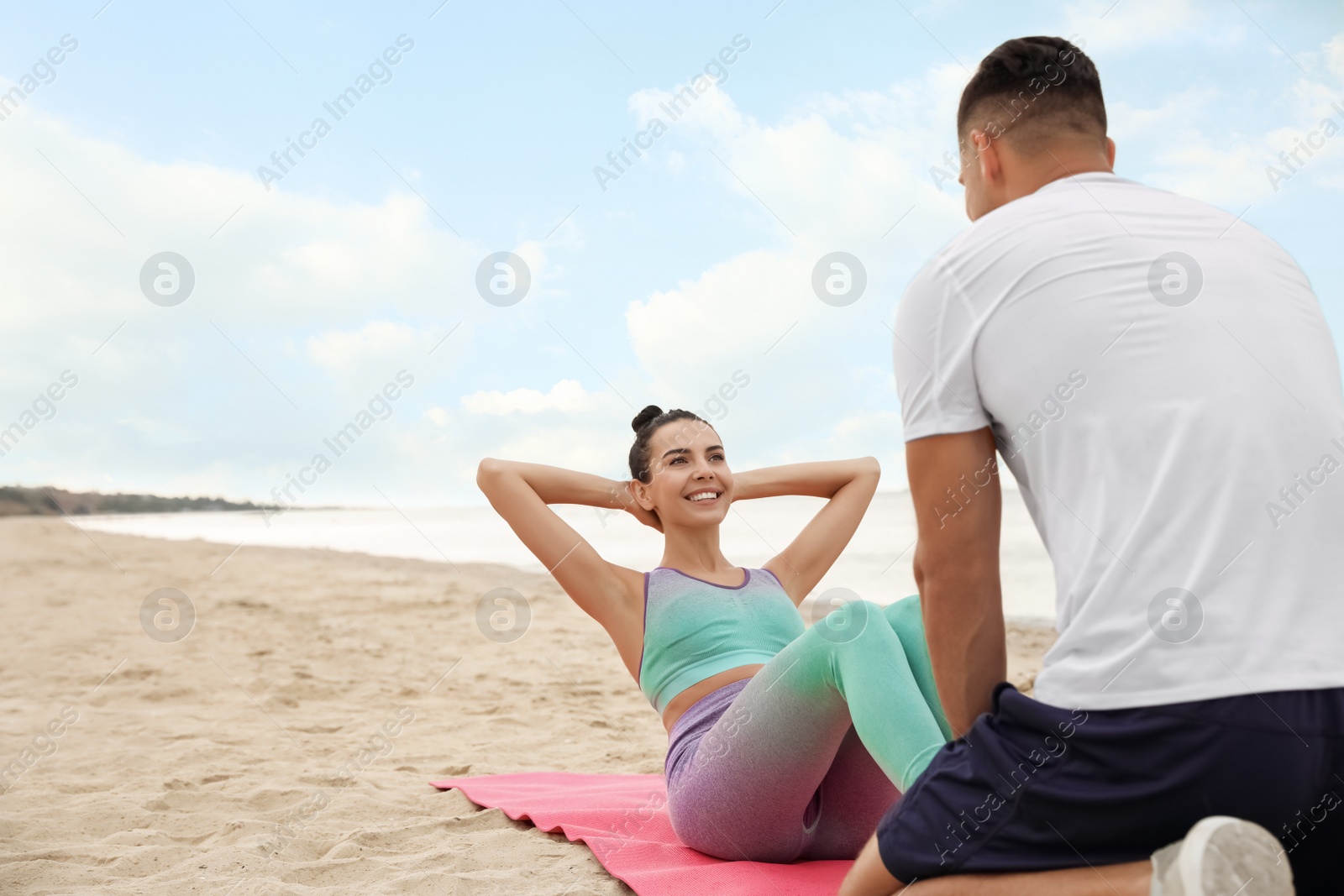 Photo of Couple doing exercise together on beach, space for text. Body training