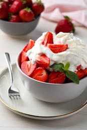Photo of Delicious strawberries with whipped cream served on white wooden table