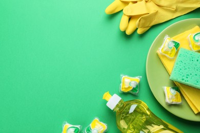 Photo of Flat lay composition with dishwasher detergent pods on green background, space for text
