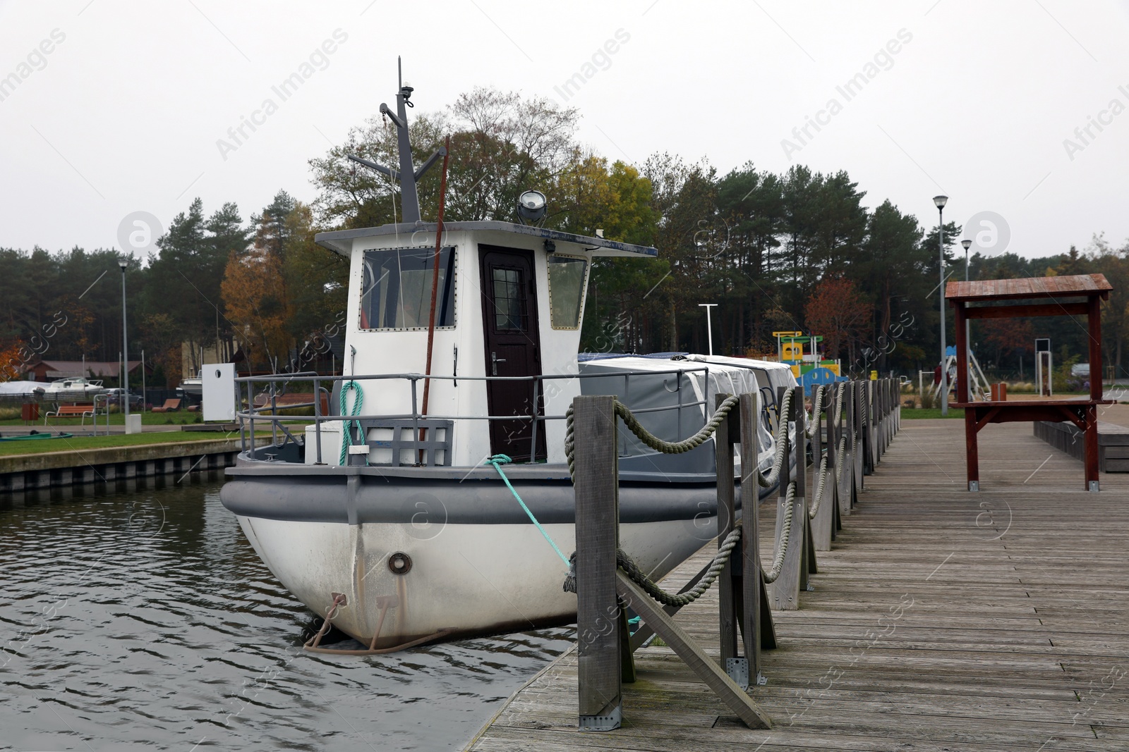 Photo of Picturesque view of wooden pier with moored boat