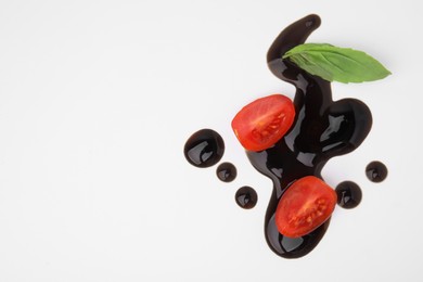 Photo of Tomatoes, basil leaf and balsamic vinegar on white background, flat lay. Space for text