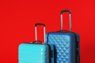Photo of Stylish modern suitcases with handles on color background
