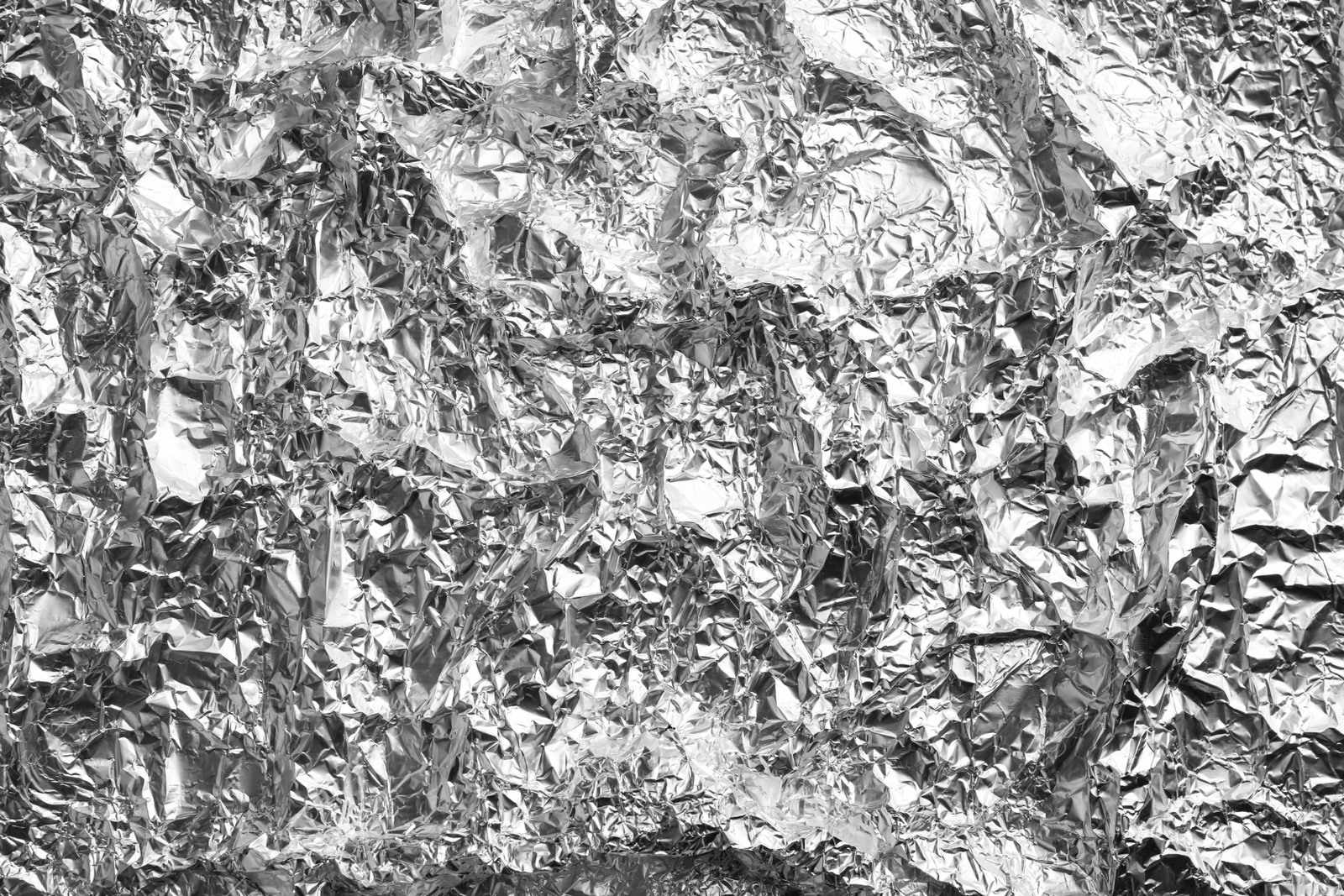 Photo of Crumpled silver foil as background, closeup view