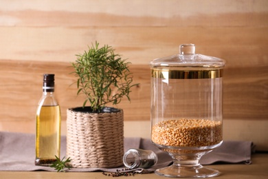 Jar with split peas on table against wooden background. Foodstuff for modern kitchen