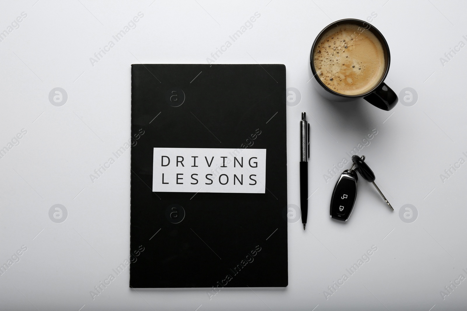 Photo of Composition with workbook for driving lessons on white background, top view. Passing license exam