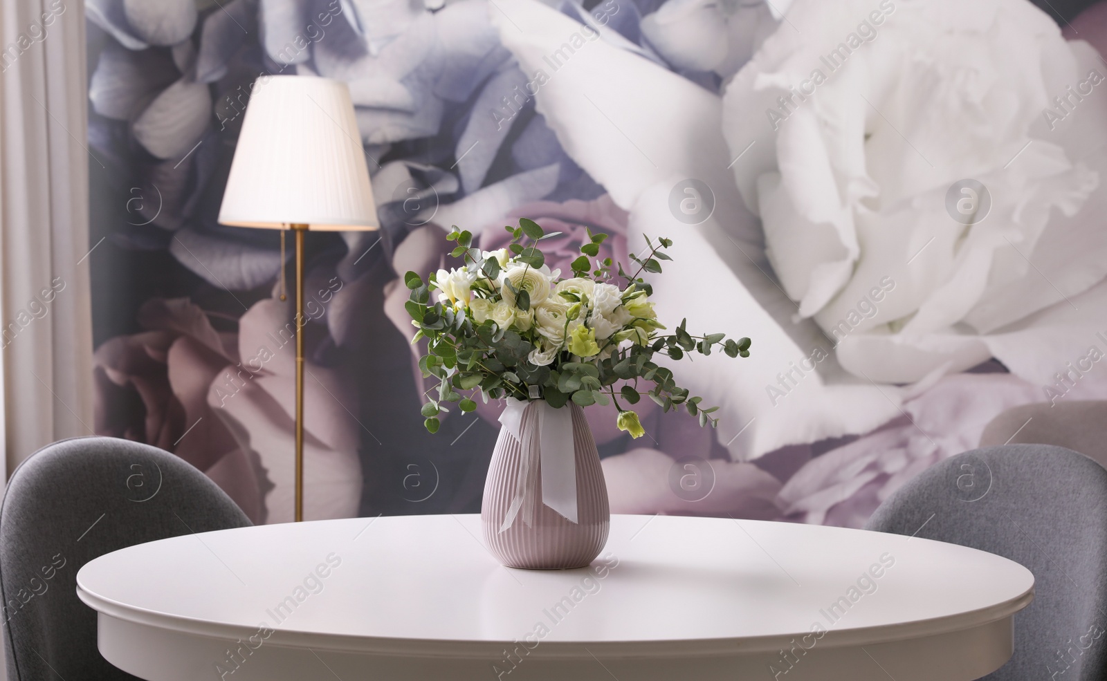 Photo of Vase with beautiful bouquet on white table indoors. Stylish interior element