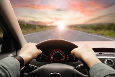 Image of Man driving modern car on sunset, closeup