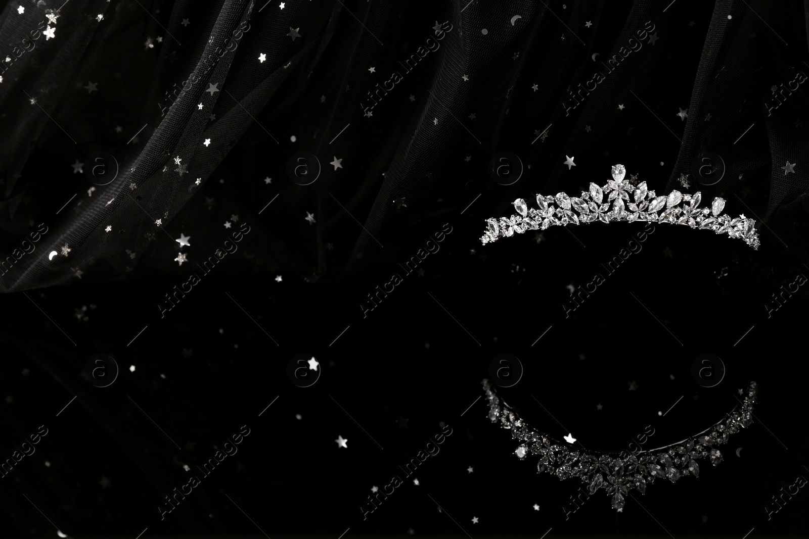 Photo of Beautiful silver tiara with diamonds on dark mirror surface. Space for text