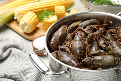Photo of Fresh raw crayfishes in pot on table, closeup