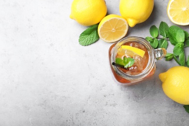 Photo of Delicious iced tea with lemon and mint on grey table, flat lay. Space for text