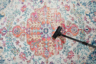 Photo of Removing dirt from carpet with modern vacuum cleaner, top view. Space for text