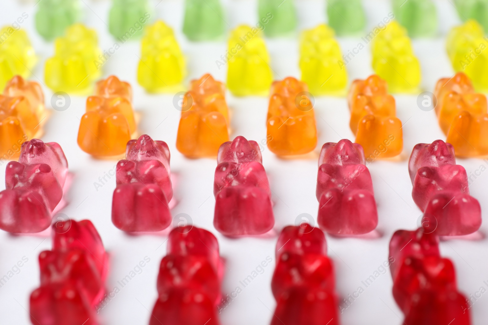 Photo of Many delicious little jelly bears on white background