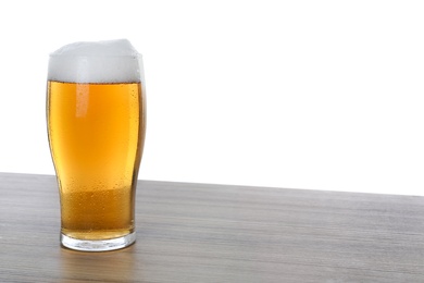 Glass of tasty beer on wooden table against white background. Space for text