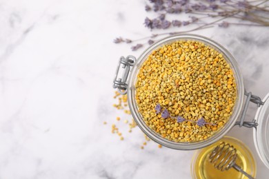 Fresh bee pollen granules, lavender, honey and dipper on light marble table, flat lay. Space for text