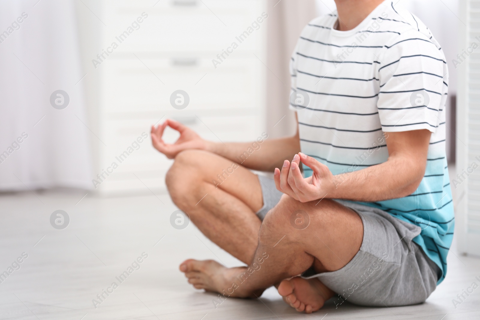 Photo of Man meditating on floor at home, closeup. Zen concept