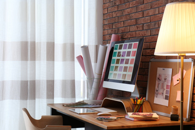 Photo of Modern computer and office supplies on wooden table. Designer's workplace