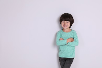 Photo of Portrait of cute little boy on white background, space for text