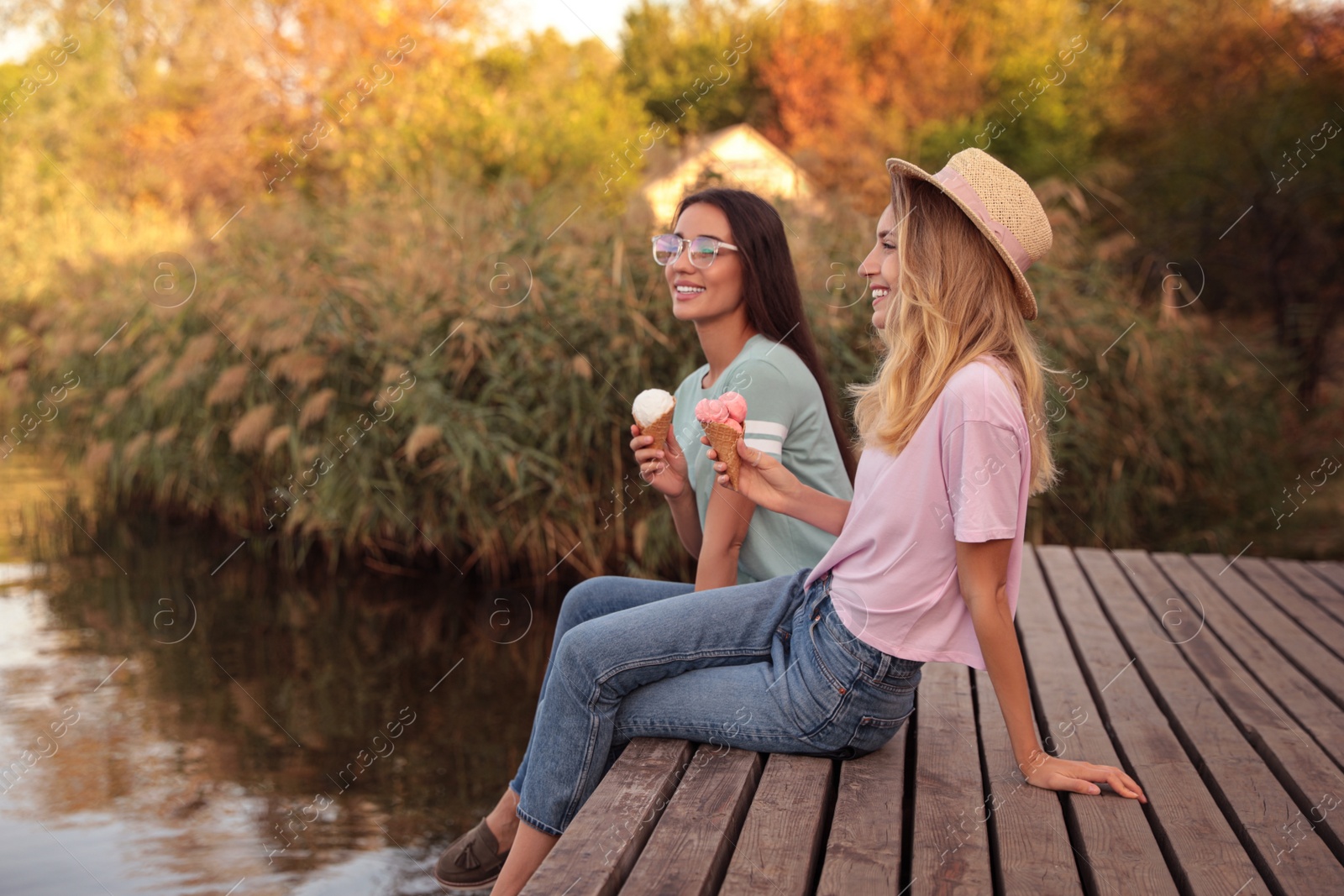 Photo of Young women with ice cream spending time together outdoors