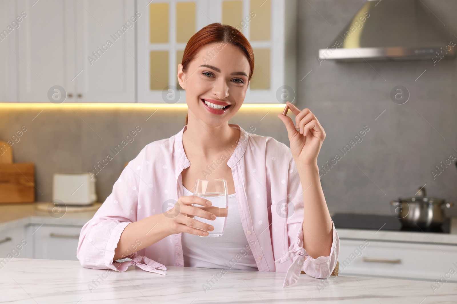 Photo of Beautiful young woman with vitamin pill and glass of water