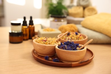 Photo of Dry flowers on wooden table indoors. Spa time