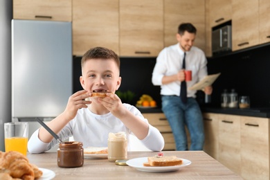 Dad and son having breakfast together in kitchen