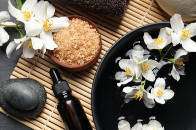 Photo of Beautiful spa composition with jasmine essential oil and fresh flowers on table, flat lay