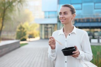 Photo of Smiling businesswoman with lunch box outdoors. Space for text