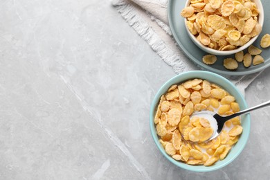 Photo of Tasty cornflakes with milk served on light grey table, flat lay. Space for text
