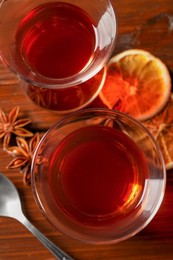 Glasses of traditional Turkish tea and ingredients on wooden table, flat lay