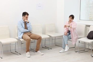 Photo of Man and woman waiting for job interview indoors