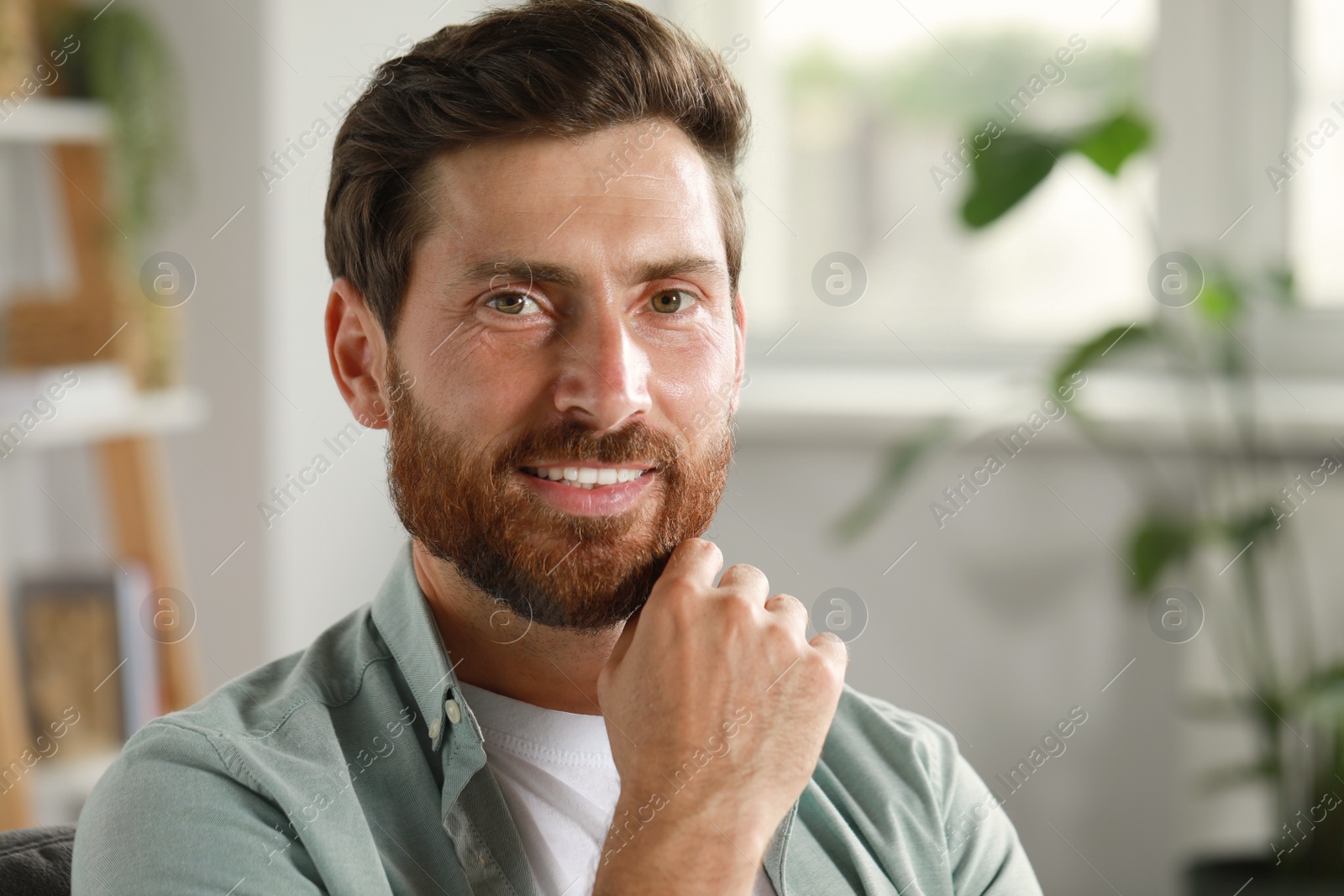 Photo of Portrait of handsome bearded man at home, space for text