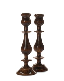 Two stylish wooden candlesticks on white background