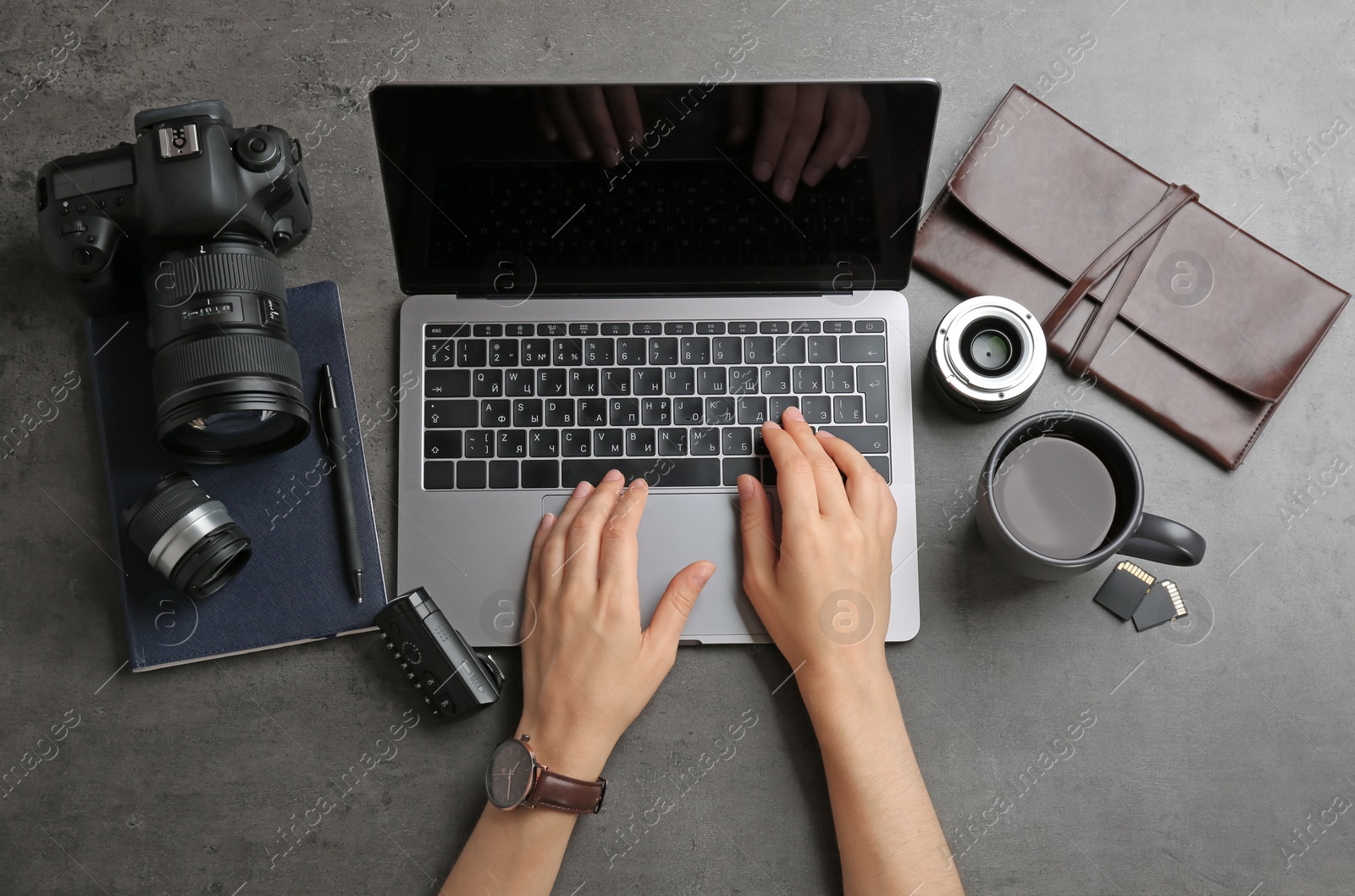 Photo of Female photographer using laptop at table, top view