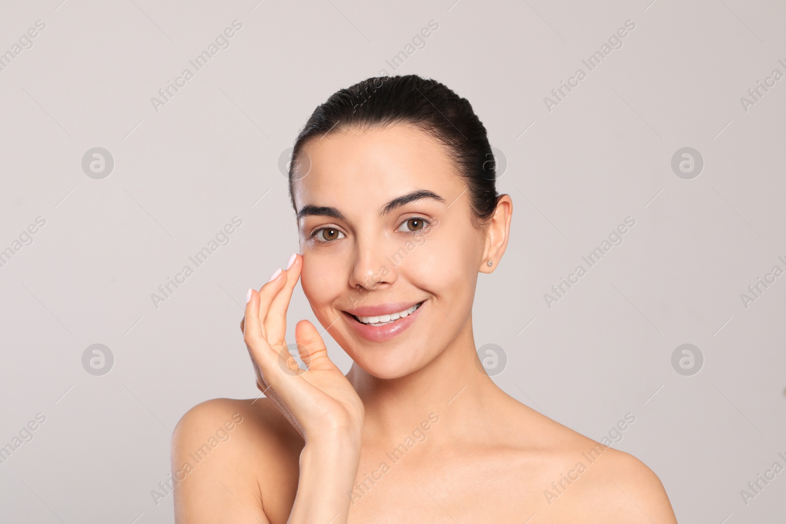 Photo of Beautiful young woman with perfect skin on light grey background