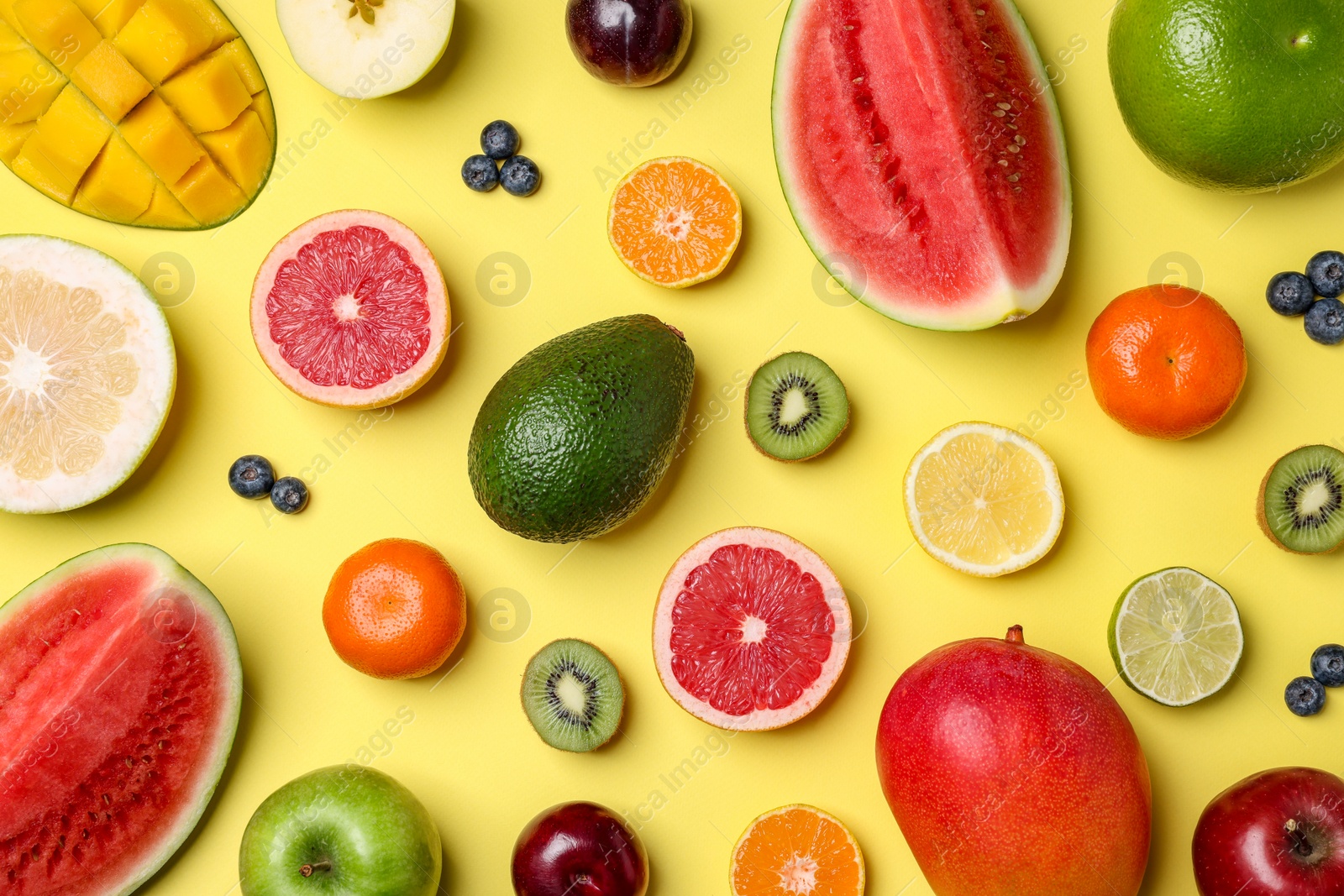 Photo of Different ripe fruits on yellow background, flat lay