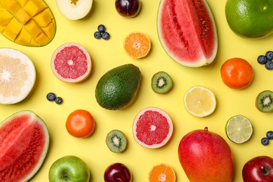 Photo of Different ripe fruits on yellow background, flat lay