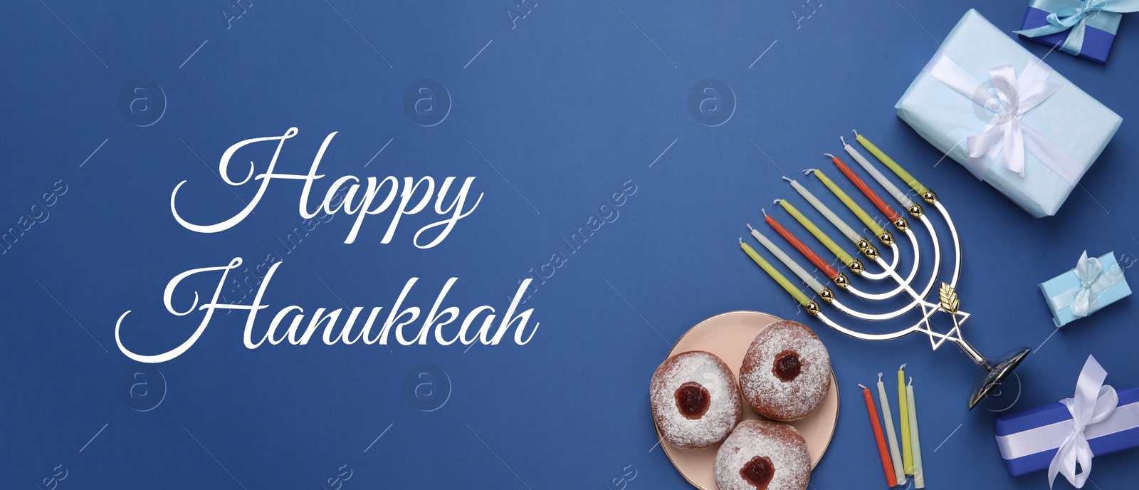 Image of Happy Hanukkah. Menorah, candles, donuts and gifts on blue background, flat lay. Banner design