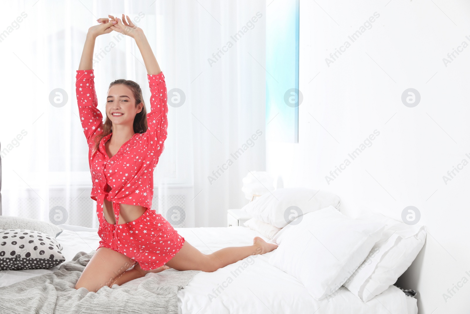 Photo of Young woman practicing yoga on bed at home. Morning fitness