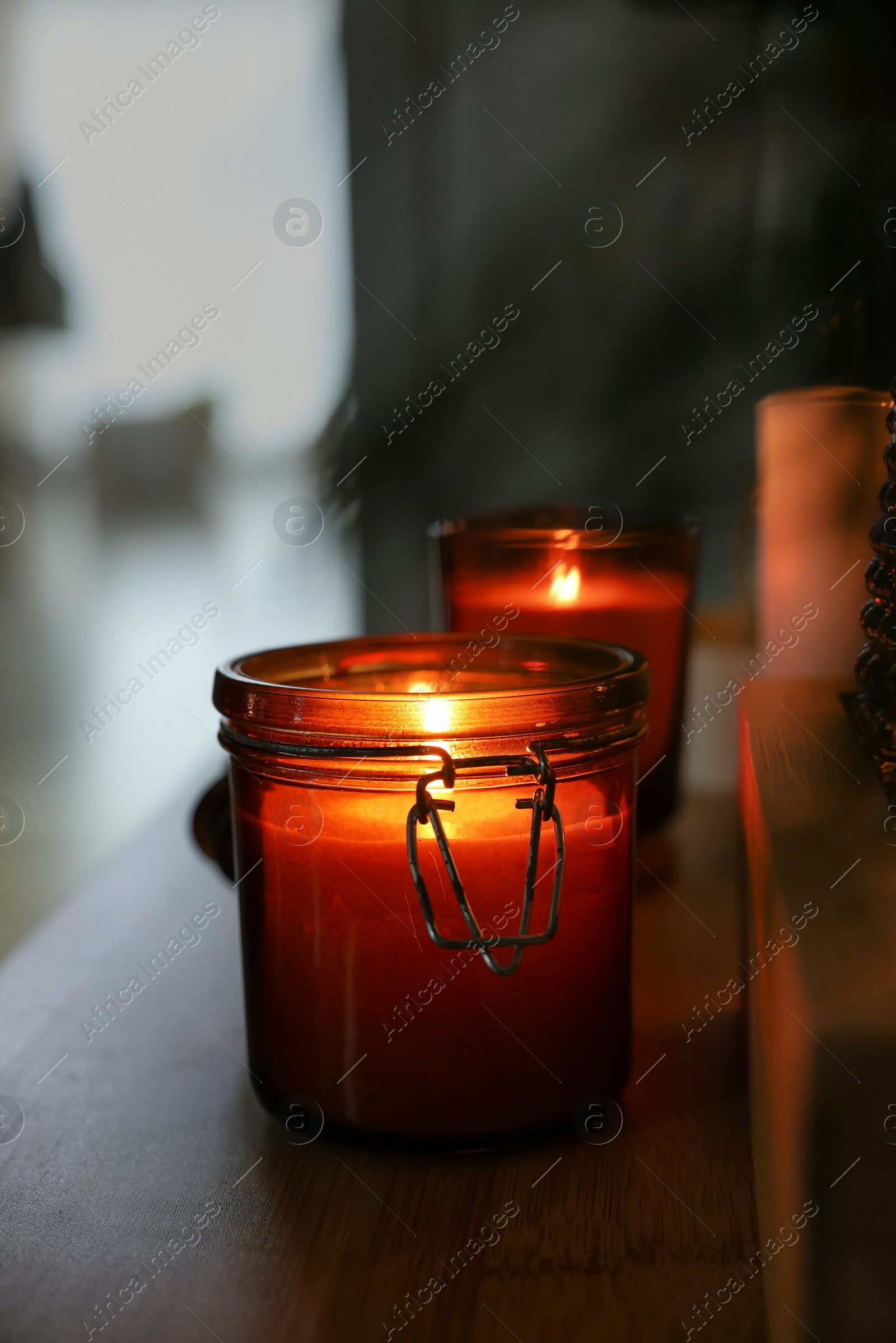 Photo of Lit candles on table in dark room. Space for text