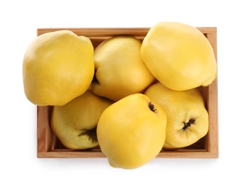 Photo of Ripe quinces in wooden crate on white background, top view