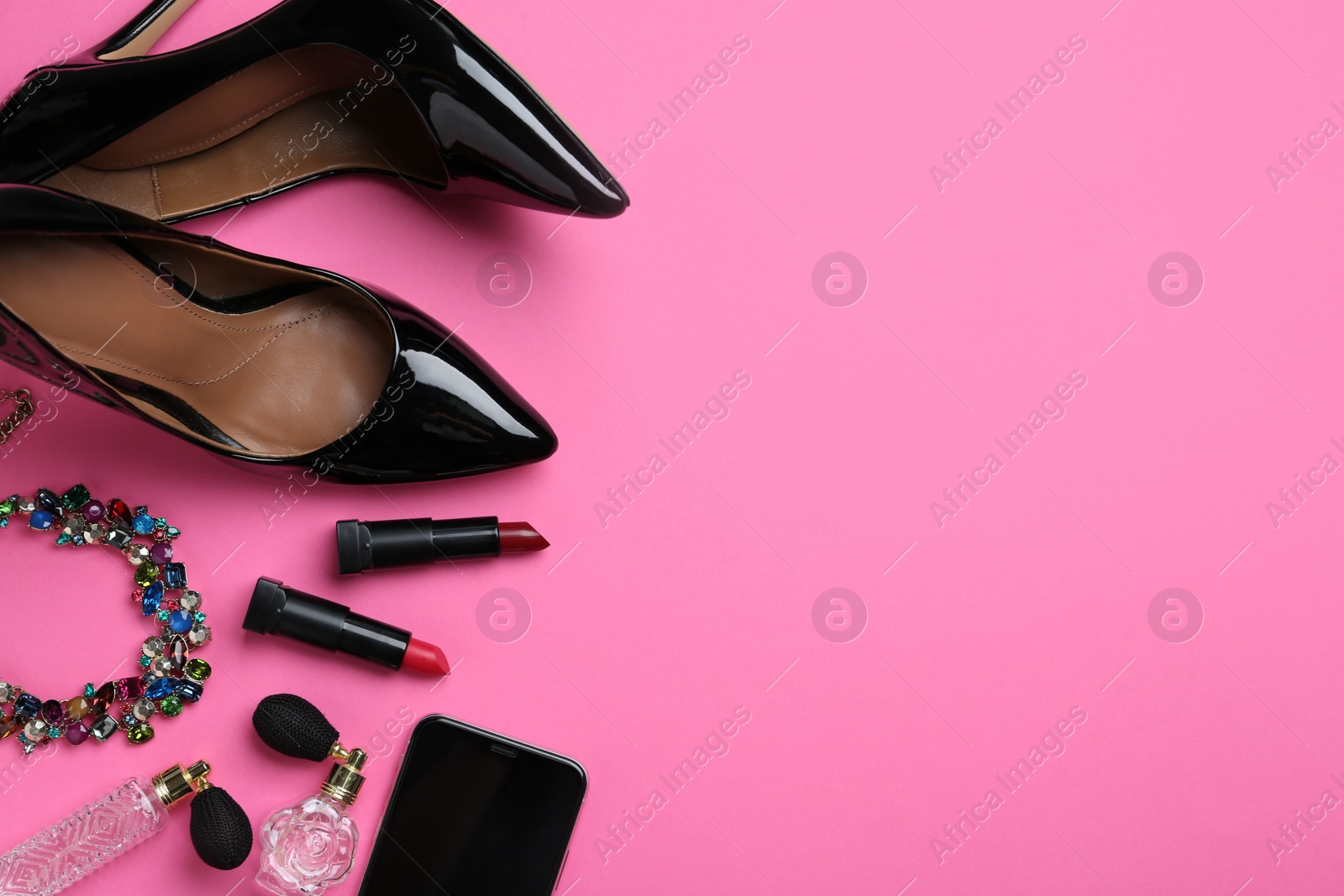 Photo of Flat lay composition with stylish shoes and lipsticks on pink background. Space for text