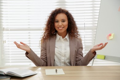 Happy African-American woman using video chat in office, view from web camera