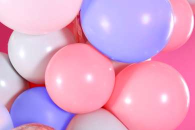 Beautiful colorful balloons on pink background, closeup. Party decor 